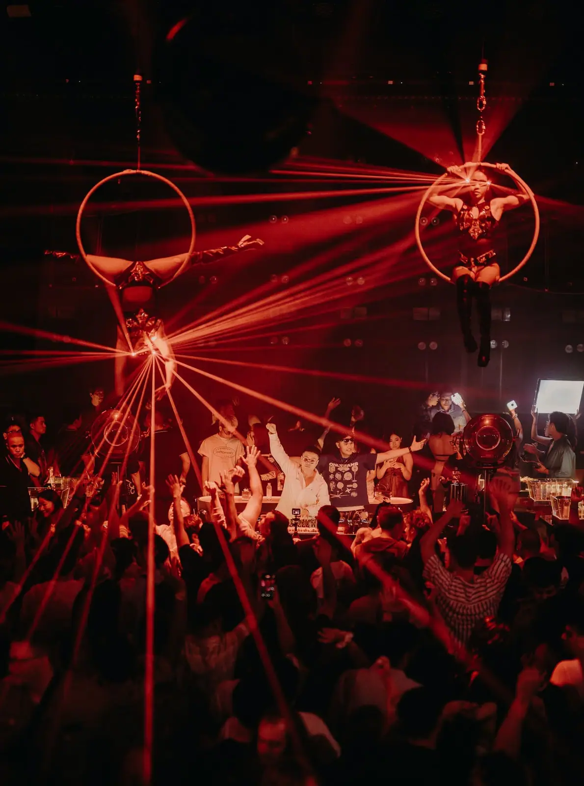 Hai nghệ sĩ múa vòng trên không giữa những tia laser đỏ phía trên sàn 1900 Le Théâtre