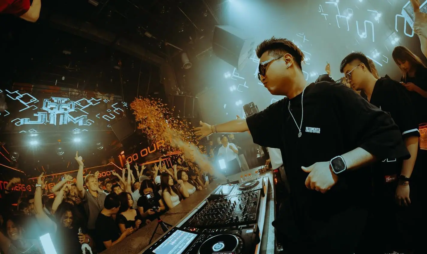 DJ tung pháo giấy về phía khán giả trước màn LED hoạ tiết xanh tại 1900 Le Théâtre