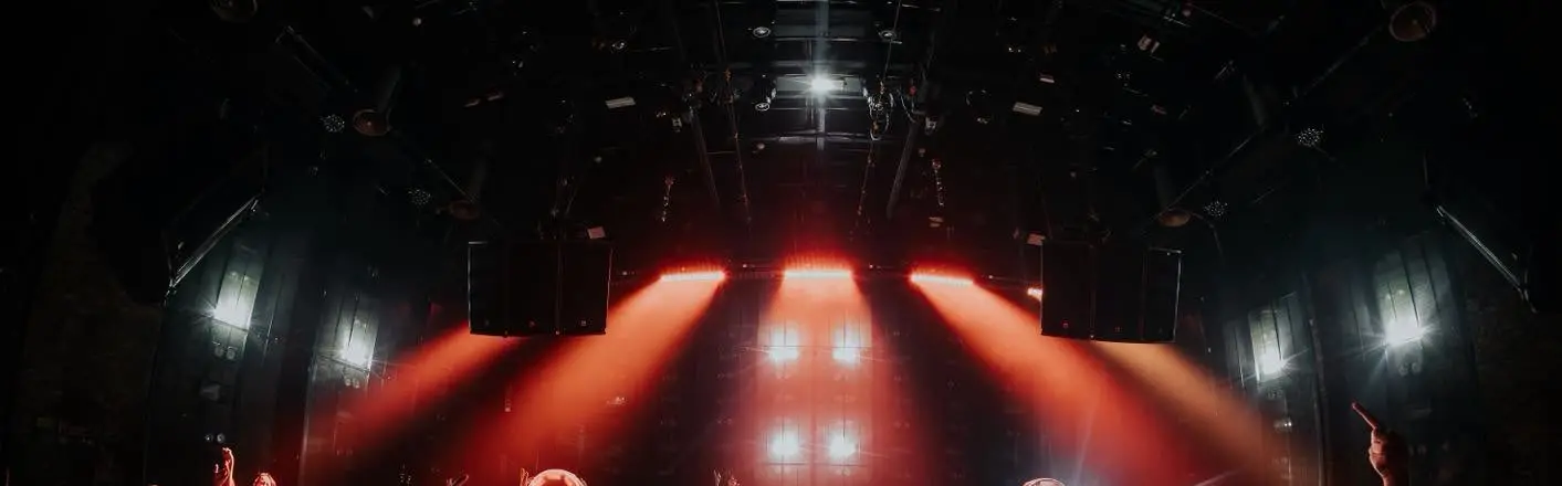 Tia đèn đỏ toả xuống từ giàn đèn giữa hai cụm loa tại 1900 Le Théâtre